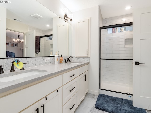 bathroom featuring vanity, wood-type flooring, a notable chandelier, a shower with door, and decorative backsplash