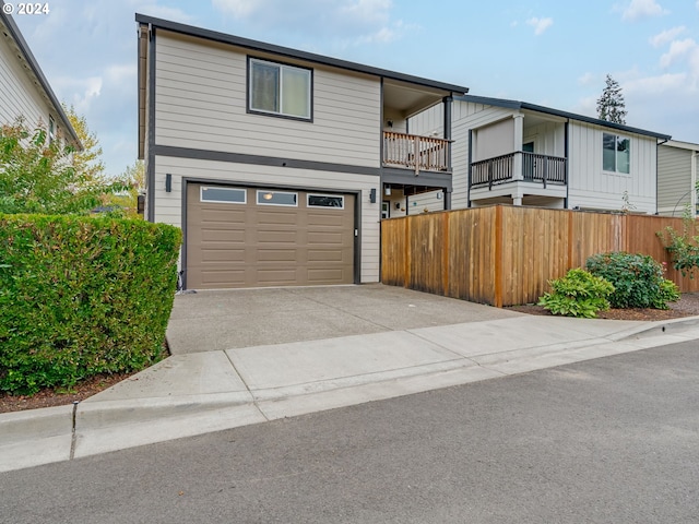 front of property featuring a balcony and a garage