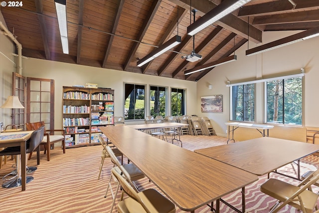 dining space with french doors, beamed ceiling, high vaulted ceiling, light colored carpet, and wood ceiling