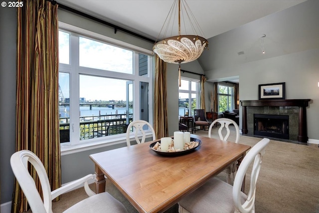 225 S Montgomery St Unit G10, Portland, OR 97201 - carpeted dining room featuring a water view, a fireplace, baseboards, vaulted ceiling, and a chandelier