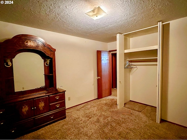 unfurnished bedroom with light carpet, a closet, and a textured ceiling