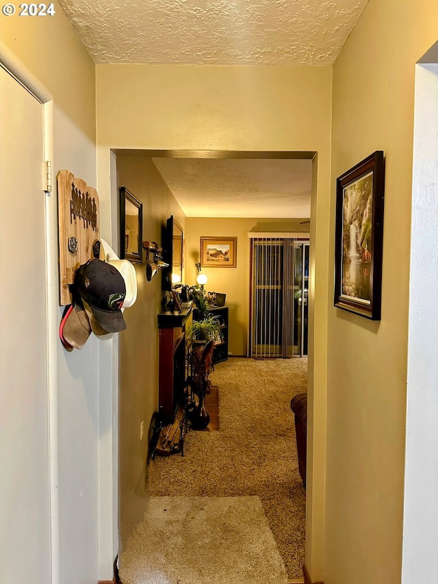 corridor featuring carpet and a textured ceiling