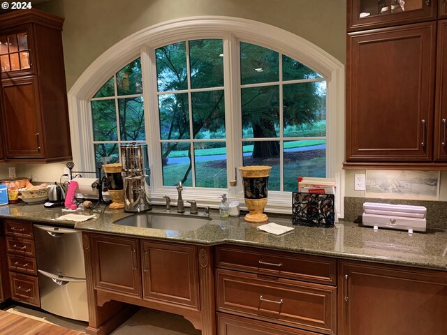 kitchen with dark stone counters, sink, and dishwasher