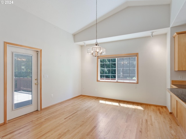 unfurnished dining area with lofted ceiling, light hardwood / wood-style flooring, and a notable chandelier