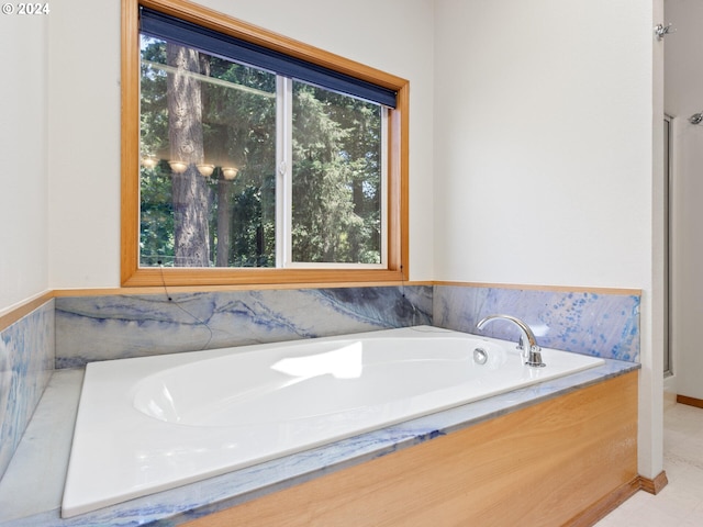 bathroom featuring a bath, plenty of natural light, and tile patterned floors