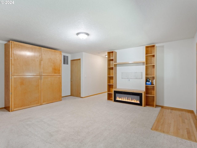 basement with a textured ceiling and light carpet