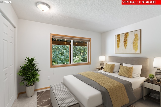 bedroom with a textured ceiling and a closet