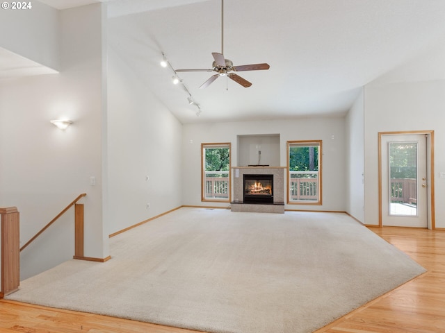 27580 SW Canyon Creek Rd, Wilsonville, OR 97070 - unfurnished living room with wood finished floors, baseboards, ceiling fan, a glass covered fireplace, and track lighting
