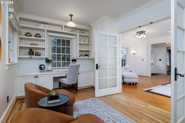 home office with crown molding, light hardwood / wood-style flooring, a chandelier, and french doors