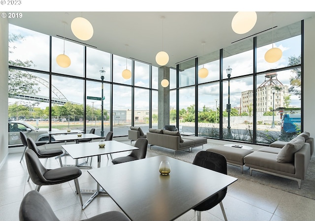 1150 NW Quimby St Unit 436, Portland, OR 97209 - dining room featuring floor to ceiling windows, a towering ceiling, and healthy amount of natural light