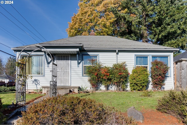 bungalow-style home with a front yard