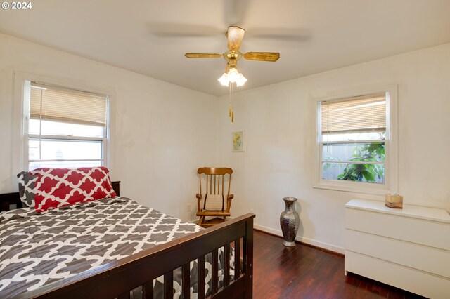 bedroom with multiple windows, dark hardwood / wood-style floors, and ceiling fan