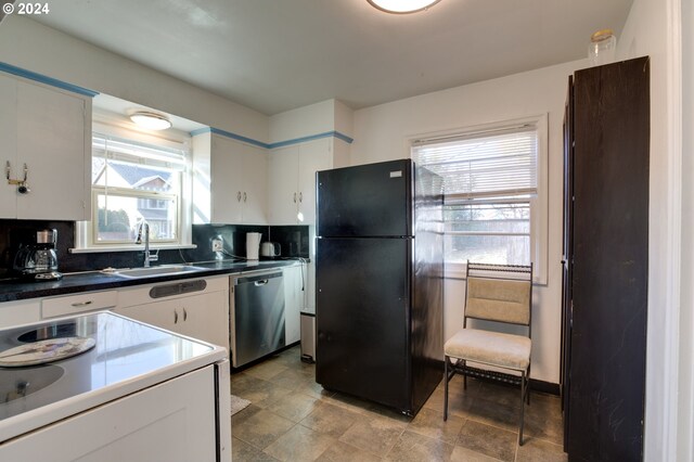 kitchen featuring black fridge, white cabinets, sink, tasteful backsplash, and stainless steel dishwasher