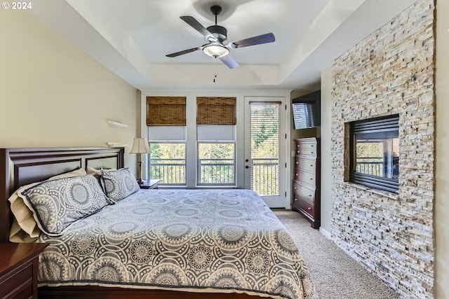 11529 SE Bateleur Way Unit C8, Happy Valley, OR 97086 - bedroom featuring access to exterior, carpet floors, a raised ceiling, a fireplace, and a ceiling fan