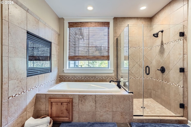 bathroom featuring plus walk in shower and tile walls