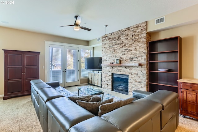 living room with ceiling fan, light colored carpet, a fireplace, and french doors