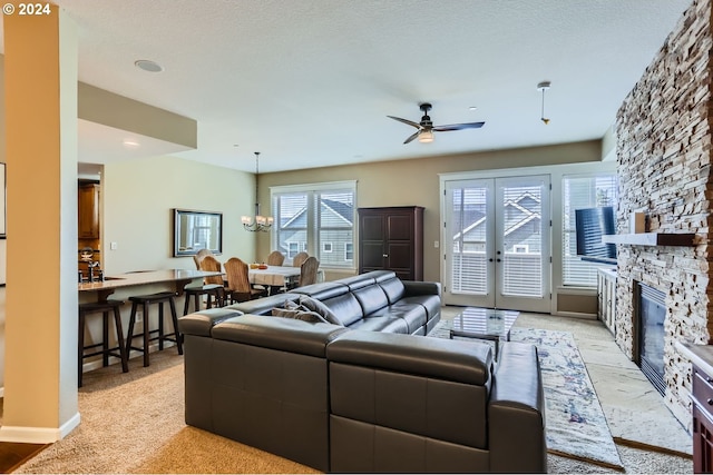 living room with light carpet, french doors, a textured ceiling, ceiling fan, and a fireplace