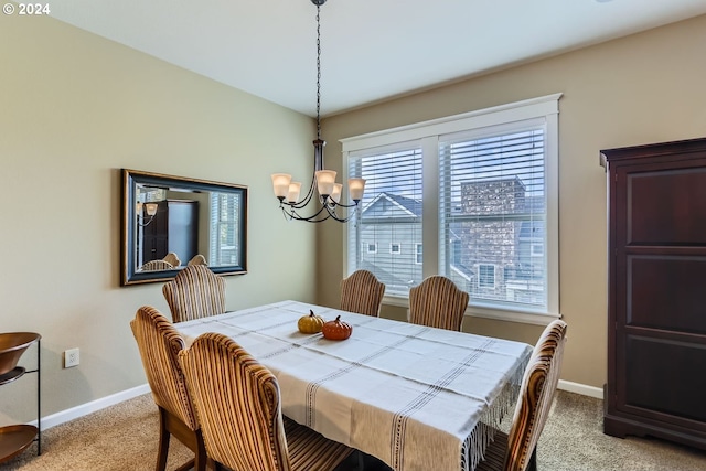 dining area with light carpet and a chandelier