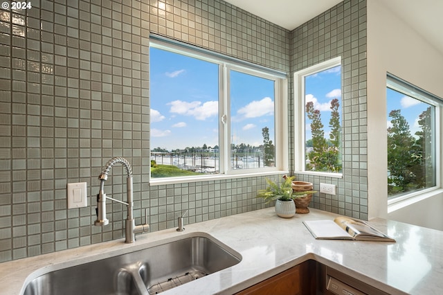 kitchen featuring sink, decorative backsplash, and a water view