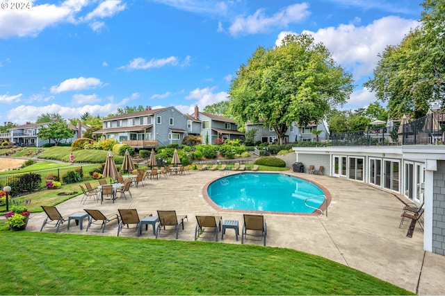 view of swimming pool with a yard and a patio area