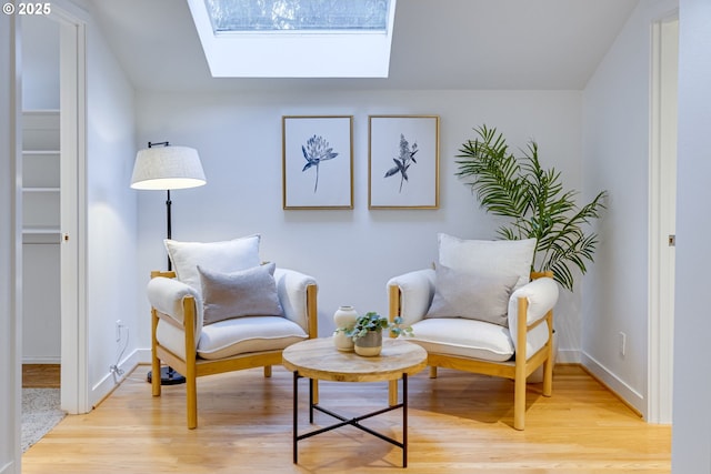 living area featuring a skylight and light wood-type flooring