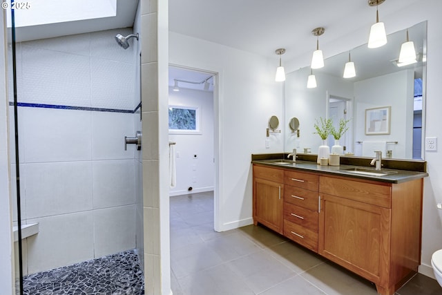 bathroom featuring vanity, a tile shower, and tile patterned flooring