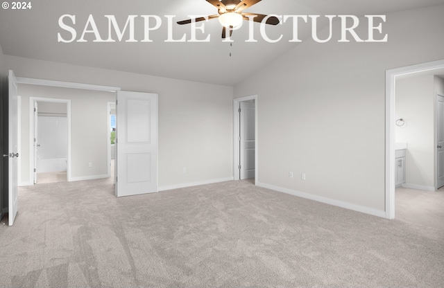 unfurnished bedroom featuring light colored carpet, ensuite bath, ceiling fan, and lofted ceiling