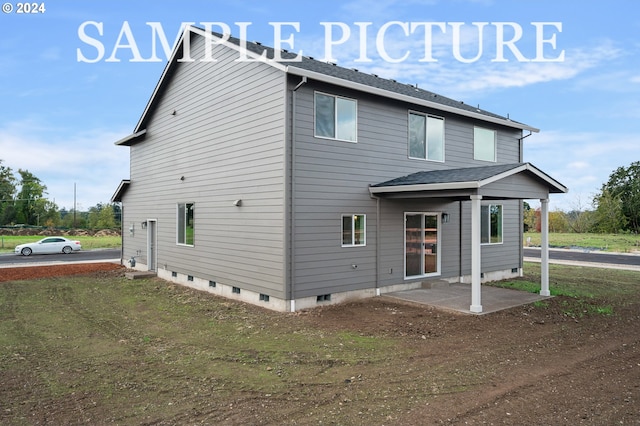 back of house featuring a lawn and a patio