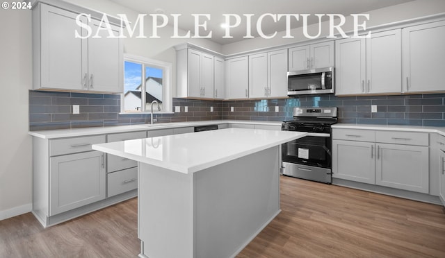 kitchen featuring a kitchen island, light hardwood / wood-style floors, sink, and appliances with stainless steel finishes