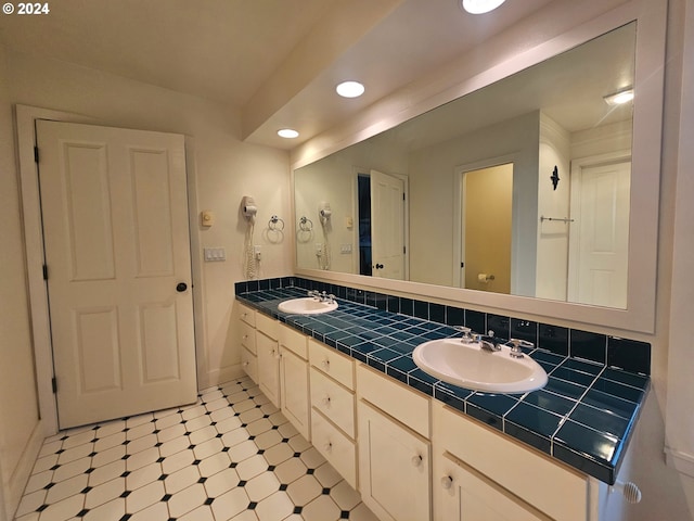 full bathroom featuring double vanity, recessed lighting, tile patterned floors, and a sink