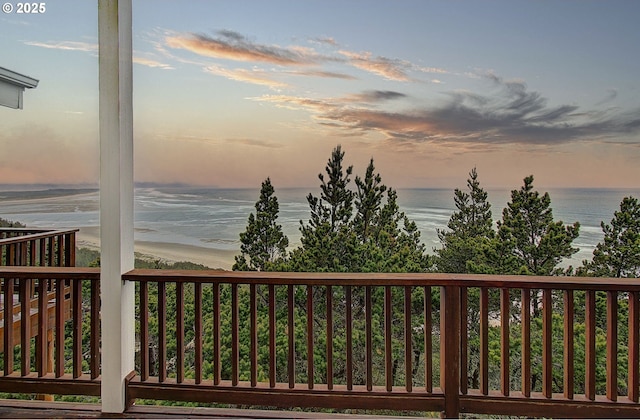 wooden terrace with a view of the beach and a water view