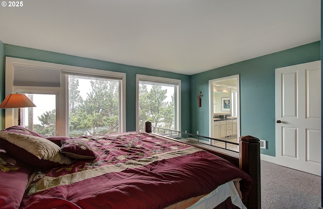 carpeted bedroom featuring baseboards and ensuite bath
