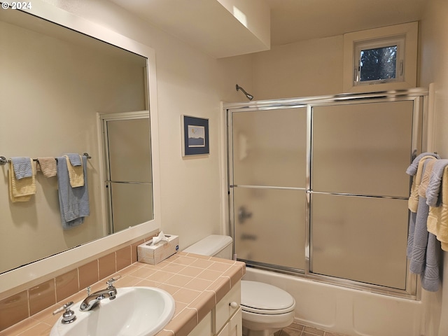 bathroom with enclosed tub / shower combo, backsplash, toilet, and vanity