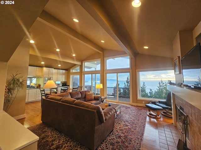 living room featuring a tile fireplace and lofted ceiling with beams