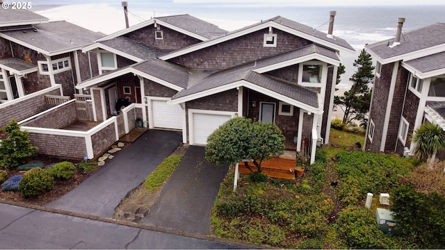 view of property with aphalt driveway and roof with shingles