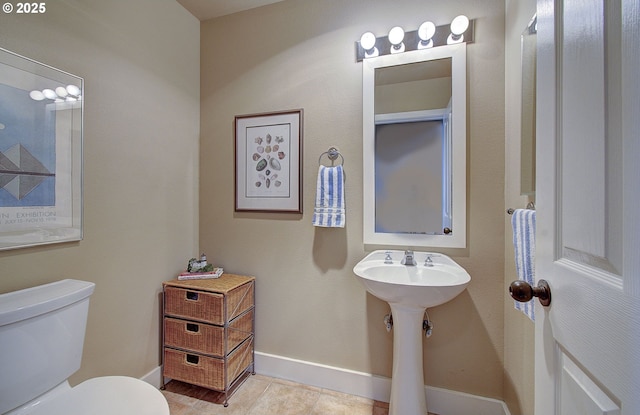 bathroom featuring tile patterned floors, toilet, and baseboards