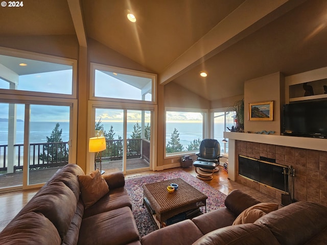 living room featuring lofted ceiling with beams, recessed lighting, and a tile fireplace