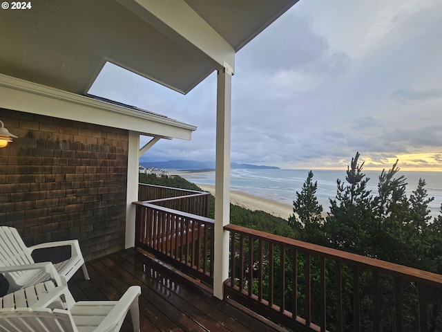 deck at dusk featuring a water view