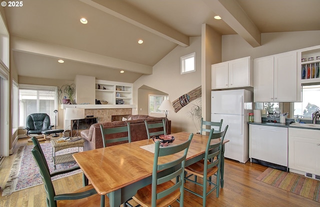dining room featuring lofted ceiling with beams, recessed lighting, dark wood finished floors, and a tiled fireplace