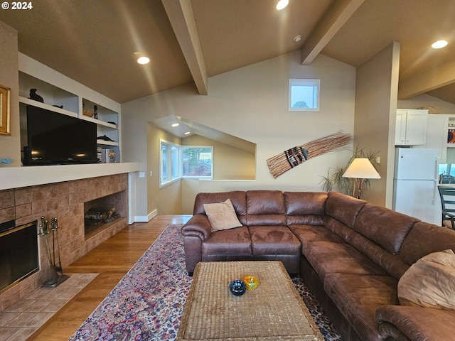 living area with lofted ceiling with beams, built in features, wood finished floors, recessed lighting, and a fireplace