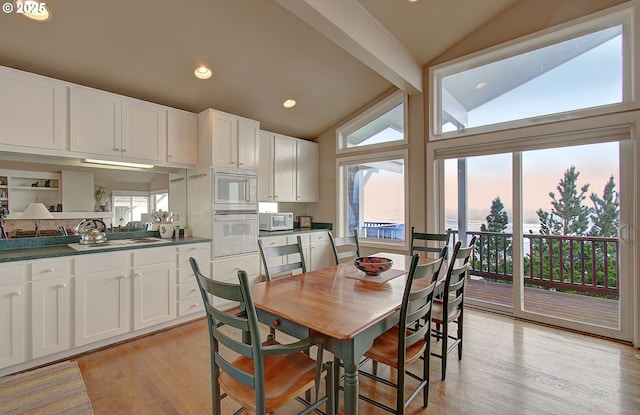 dining room featuring recessed lighting, vaulted ceiling, and light wood-type flooring