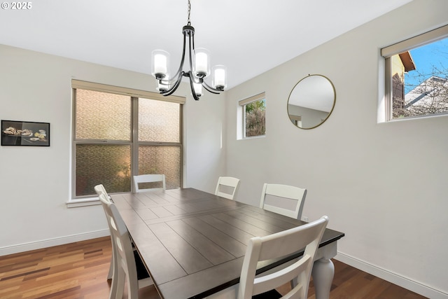 dining room with hardwood / wood-style floors and an inviting chandelier