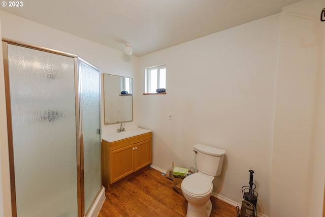 bathroom with wood-type flooring, vanity, toilet, and an enclosed shower