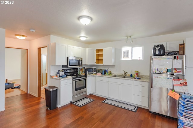 kitchen featuring white cabinets, sink, a textured ceiling, dark wood-type flooring, and stainless steel appliances