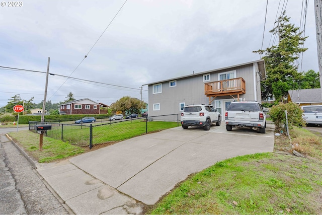 view of front of property with a balcony and a front lawn