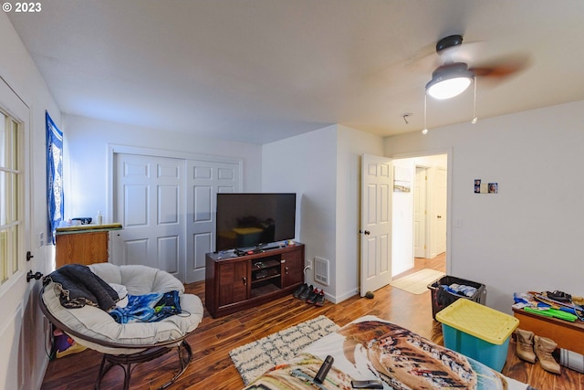 living room featuring ceiling fan and hardwood / wood-style floors