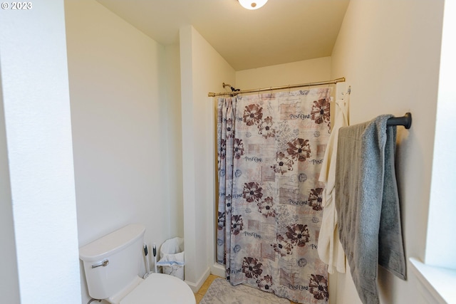 bathroom featuring walk in shower and toilet