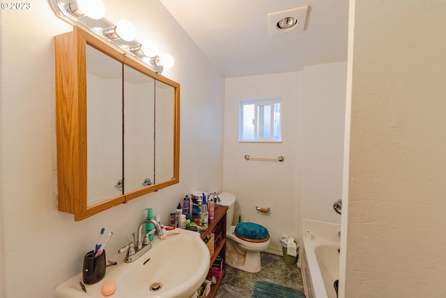 bathroom featuring sink, a tub, and toilet