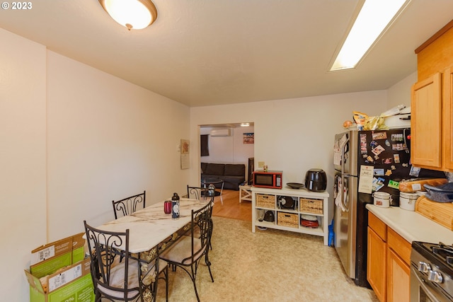 kitchen featuring appliances with stainless steel finishes, light carpet, and a wall mounted air conditioner