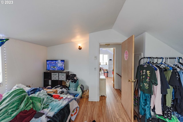 bedroom with lofted ceiling and light hardwood / wood-style floors